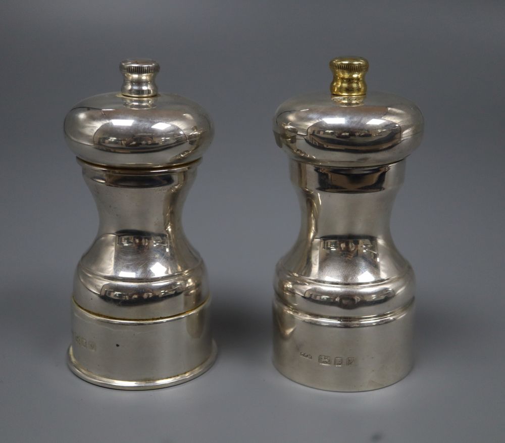 A pair of modern silver pepper mills, David R. Mills, London, 1995 & 1998, 11.1cm, one with gilded finial.